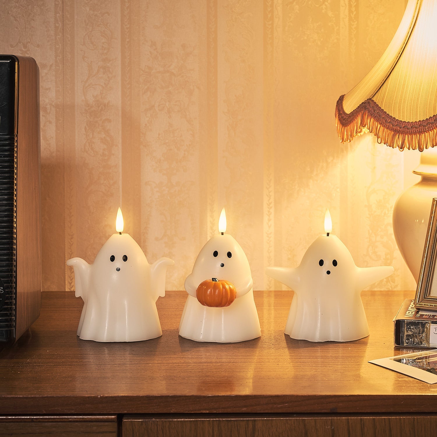 Trio of ghost-shaped LED candles creating a warm, flickering glow