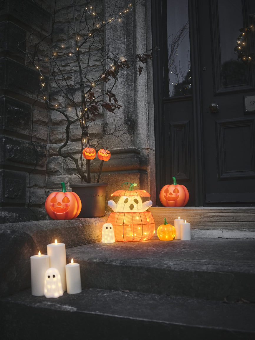 Doorstep decorated with pumpkin and ghost lights