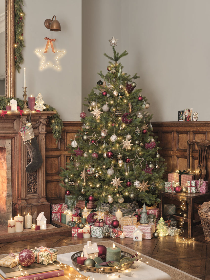 Christmas tree decorated with traditional lights, decorations, and candles