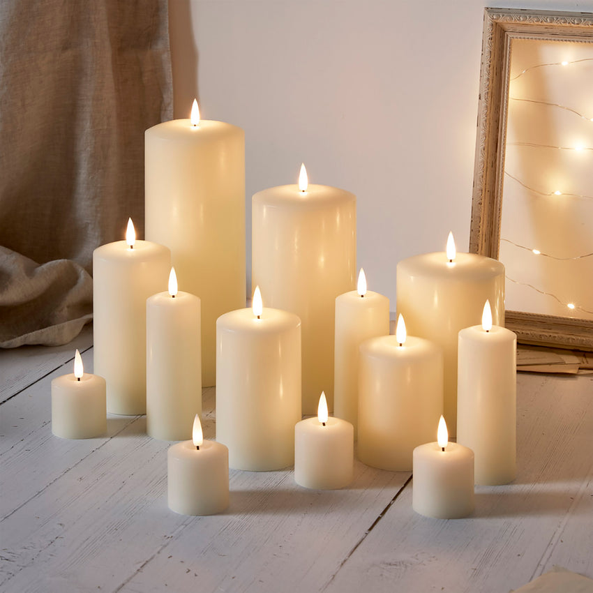 Selection of LED candles for use at a wedding, styled on a rustic wooden floor and back drop