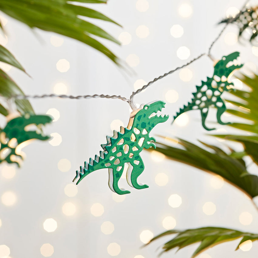 Dinosaur fairy lights on a green leaf background