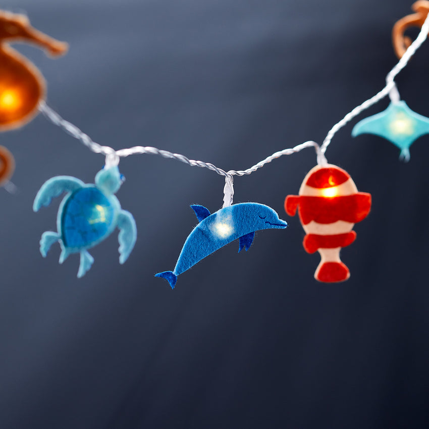 Under the sea fairy lights with felt fishes on a deep blue sea background