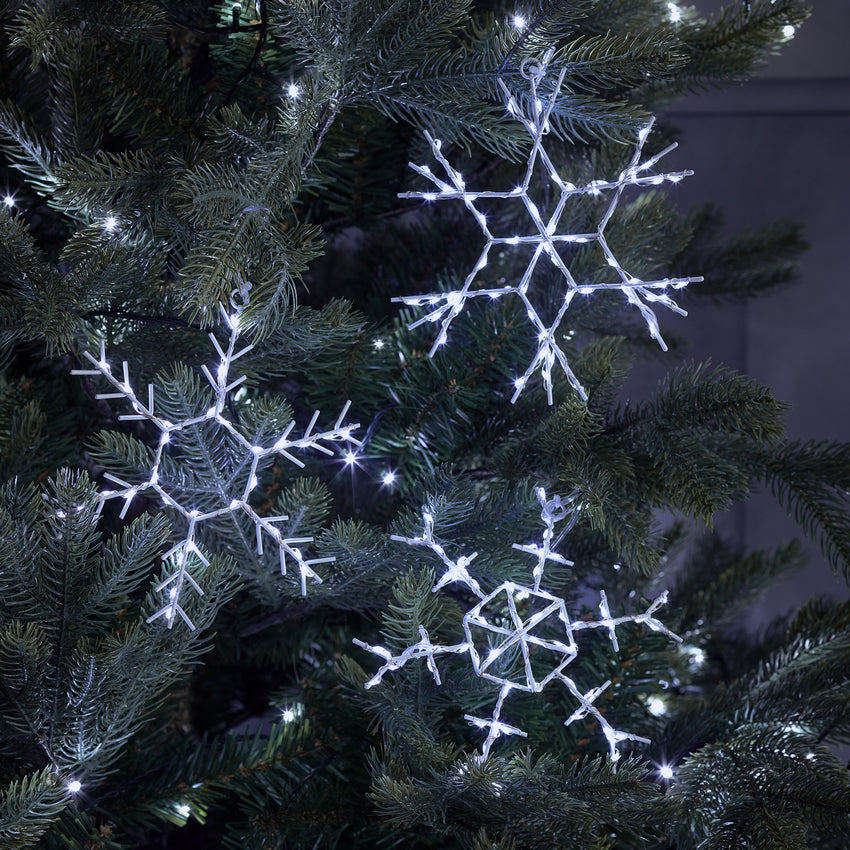 Trio of white Christmas snowflake lights styled on a Christmas tree