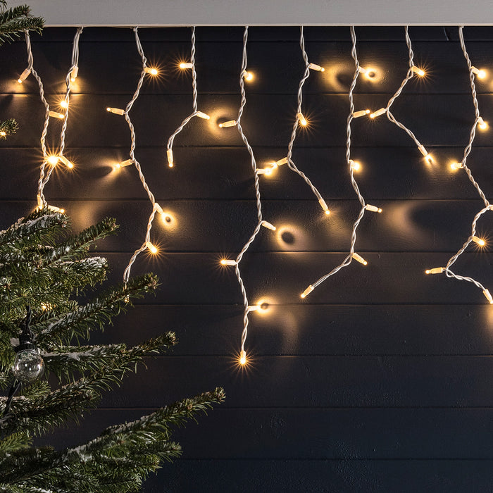 Warm white connectable icicle lights displayed on an outdoor wall