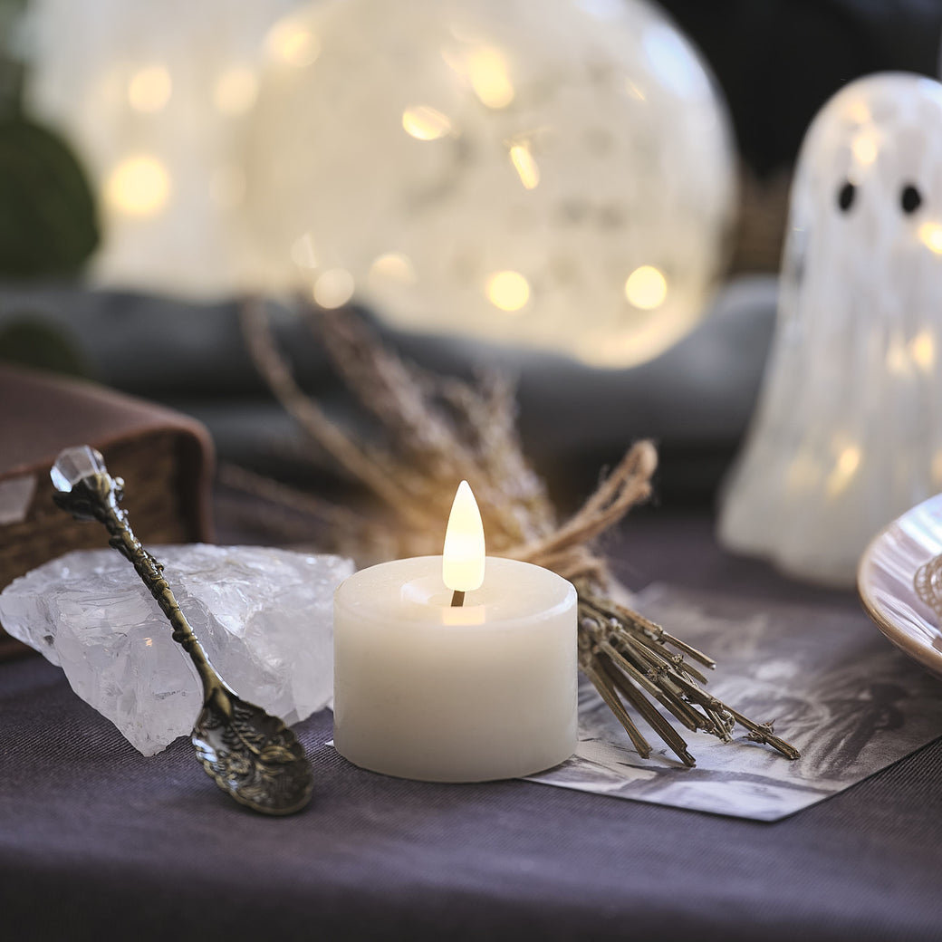 Mini votive candle on a table decorated for Halloween