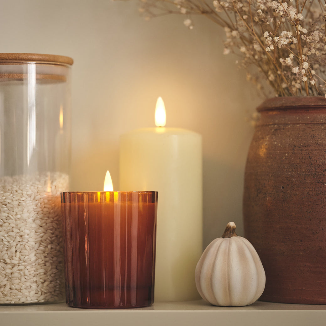 LED candles and pumpkin decoration on a shelf