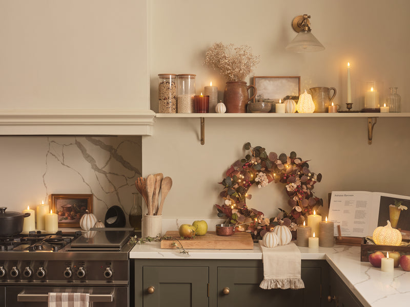 Autumnal decorated kitchen with LED candles, pumpkins, and foliage