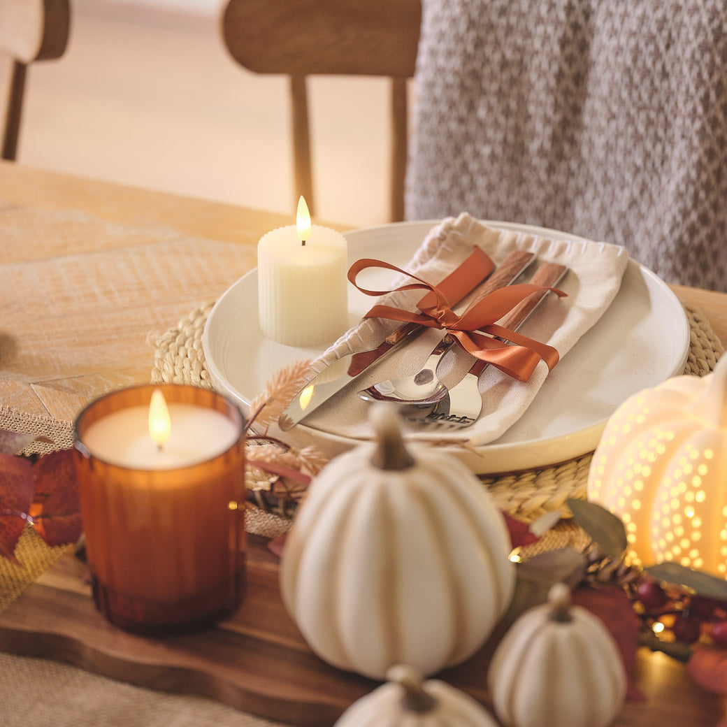 Autumnal dining table place setting with a votive candle
