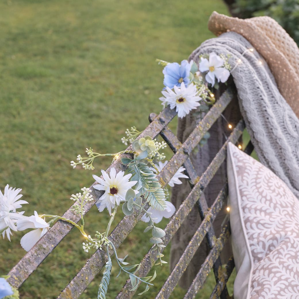 A blue bloom garland wrapped around a bench