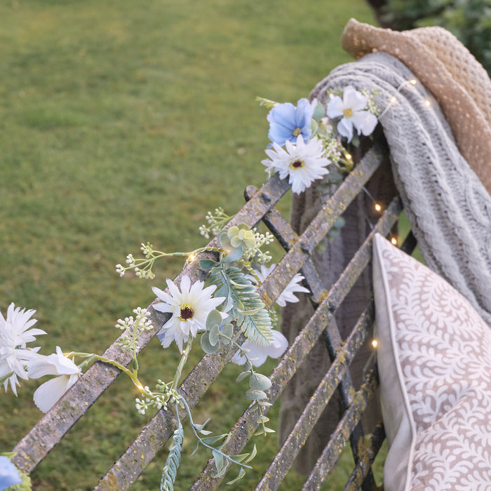 A blue bloom garland wrapped around a bench