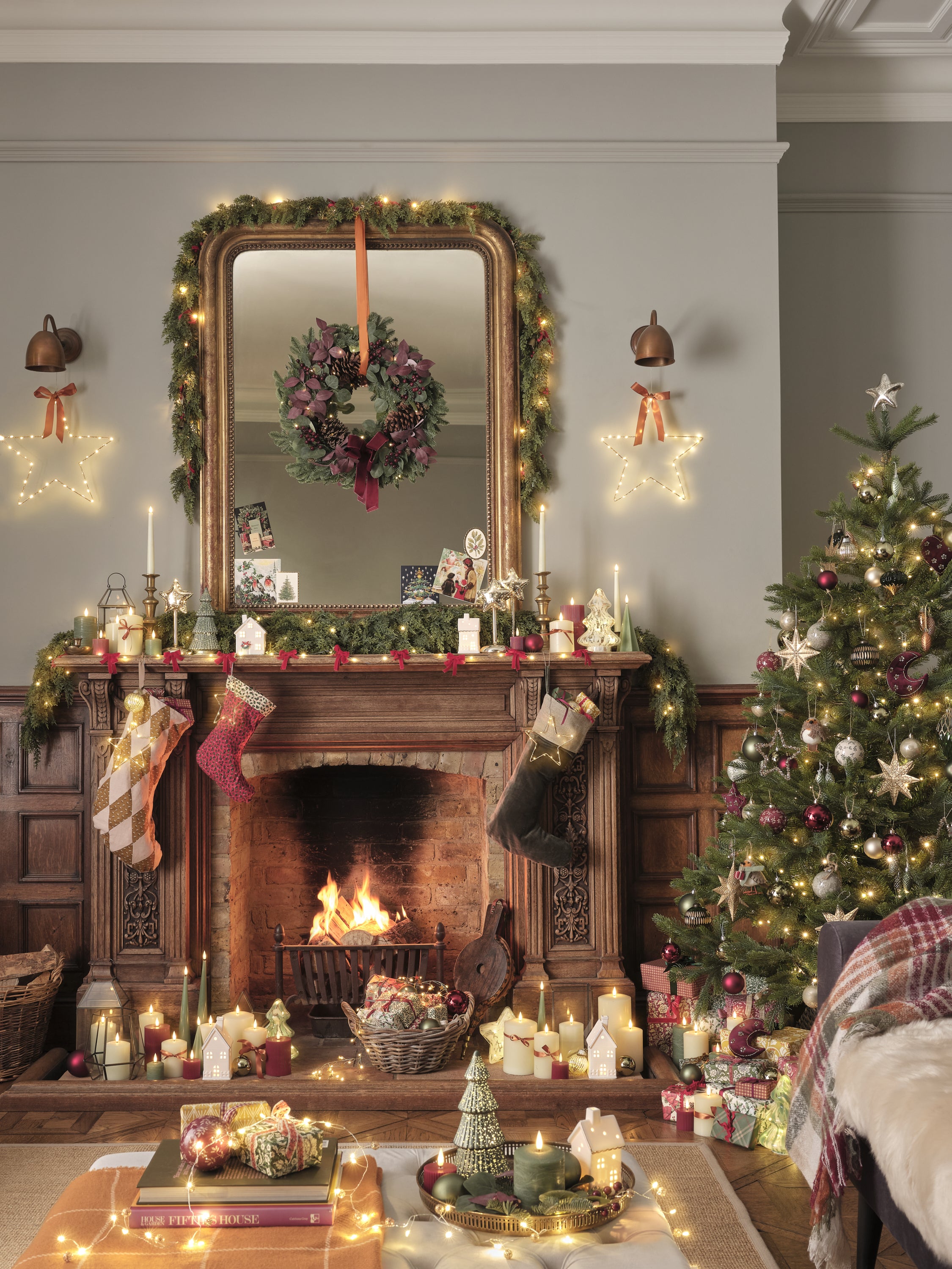 Fireplace and tree decorated with traditional lights, decorations, and candles