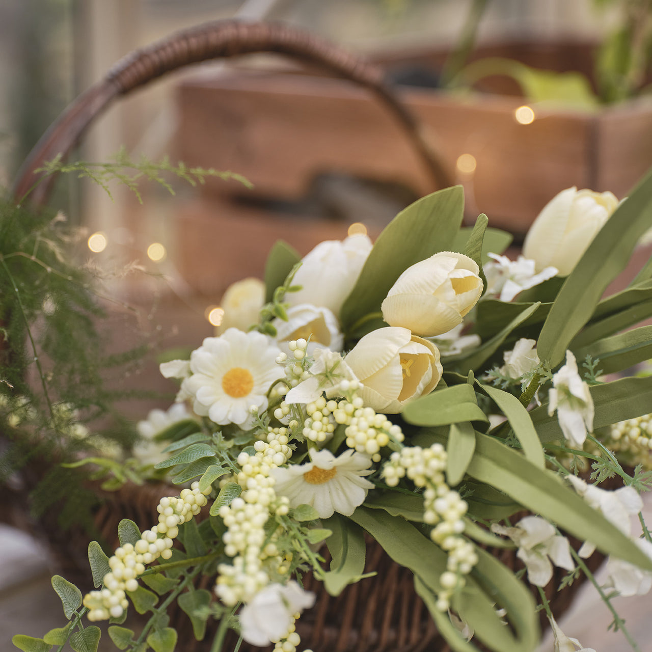 A yellow tulip and daisy bouquet in a basket
