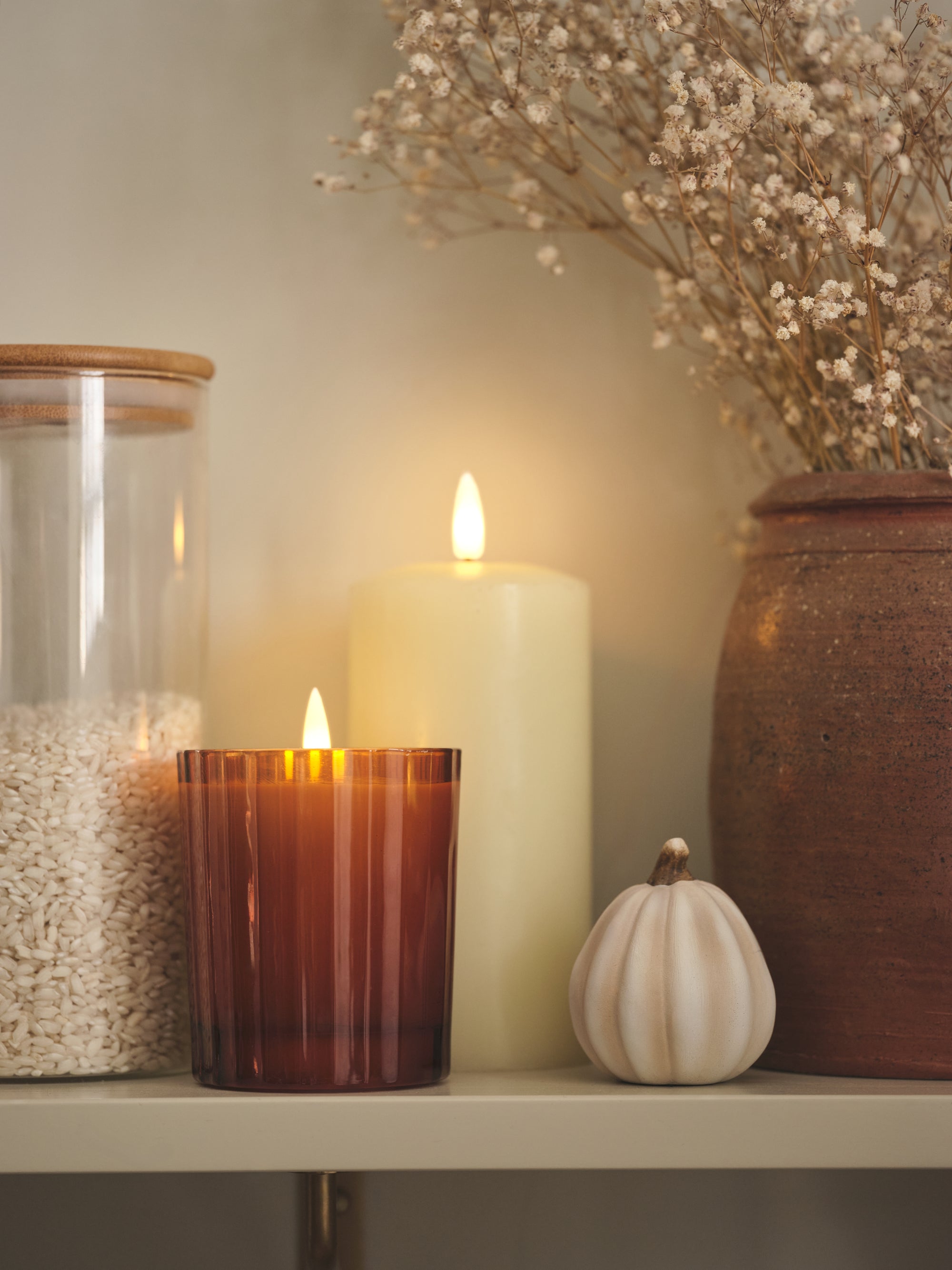 LED candles and pumpkin decoration on a shelf