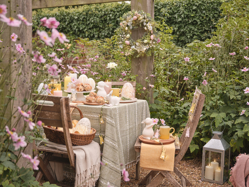 Outdoor table with porcelain bunny and glass egg decorations 