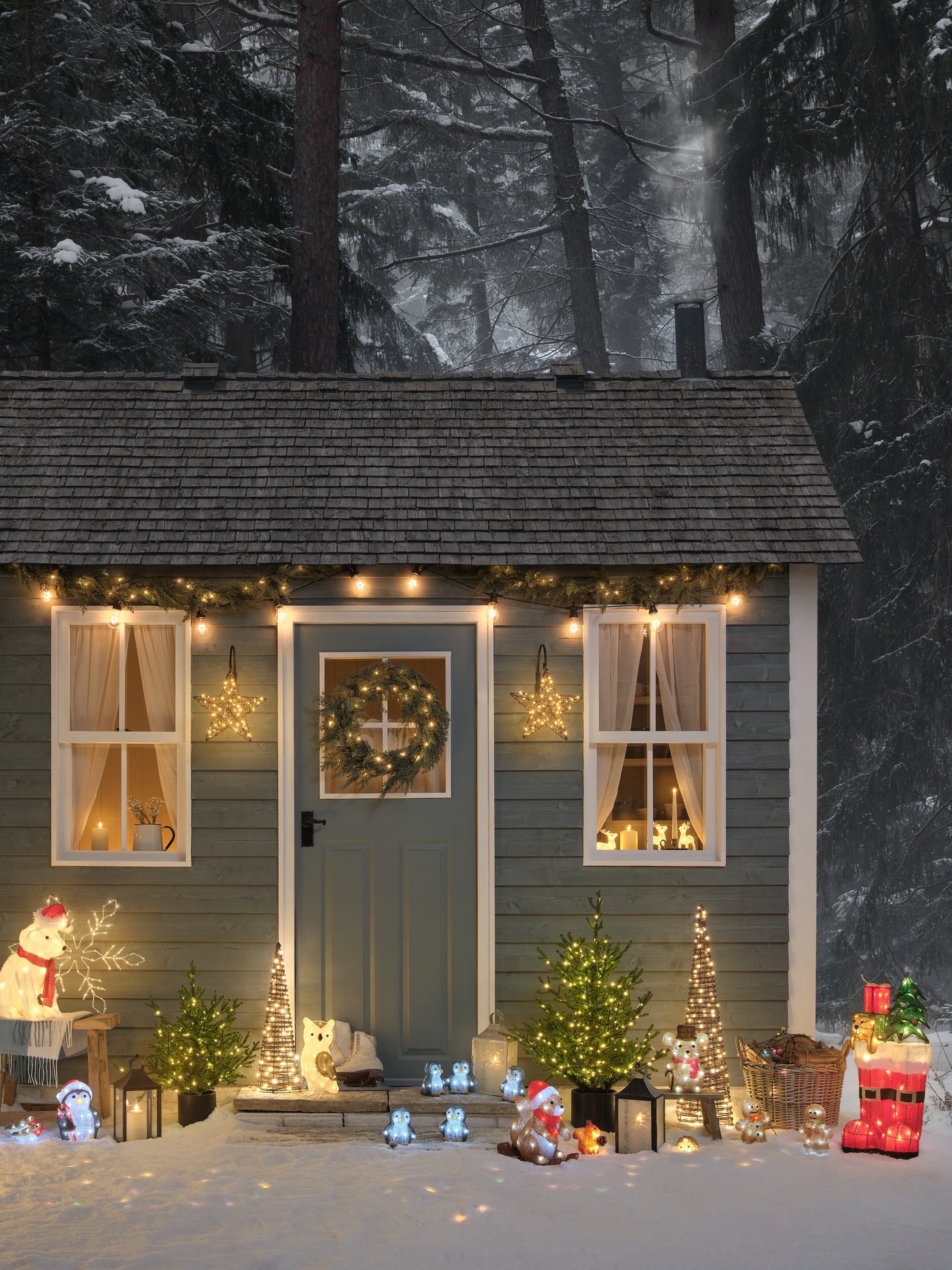 Front garden decorated for Christmas with light up animal figures, lanterns, and foliage
