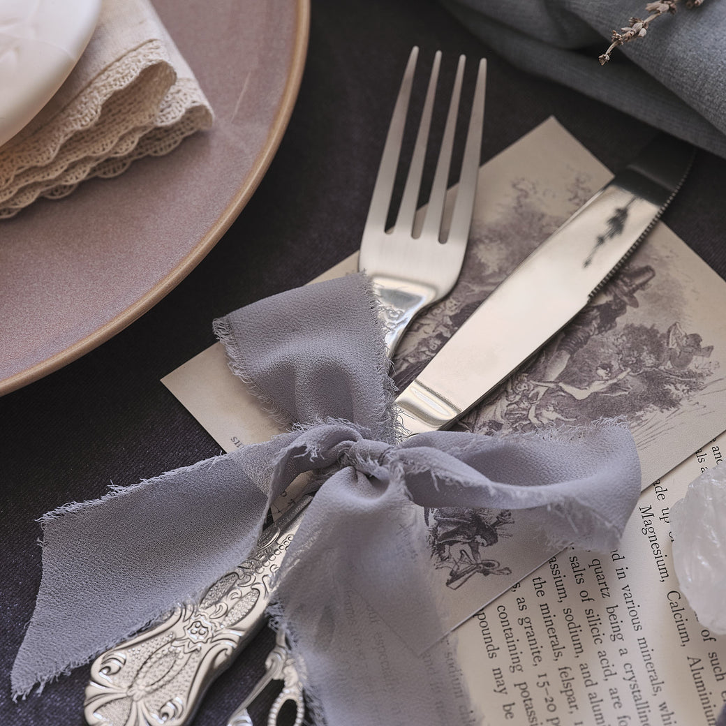 Silver cutlery tied with lilac ribbon