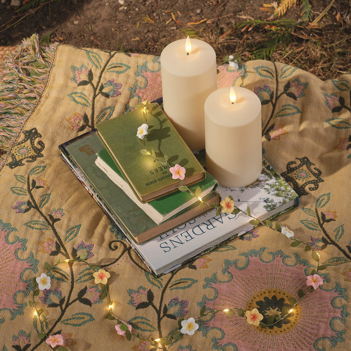 Daisy garland and LED candles on a picnic blanket