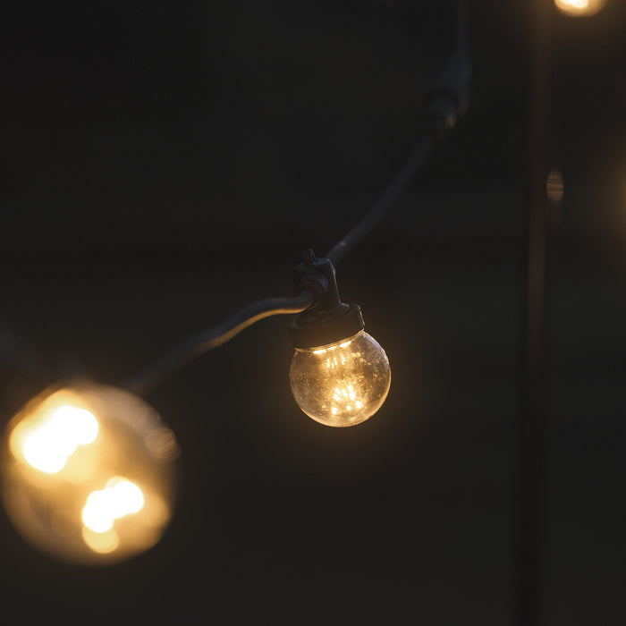 A festoon bulb glows in the darkness
