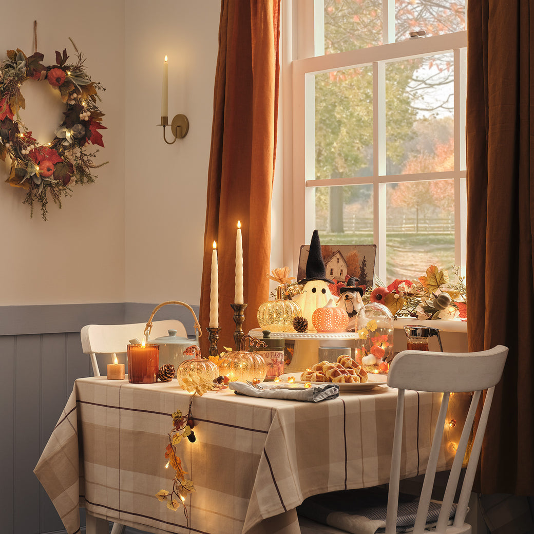 Table decorated with LED candles, pumpkin decorations and ghosts