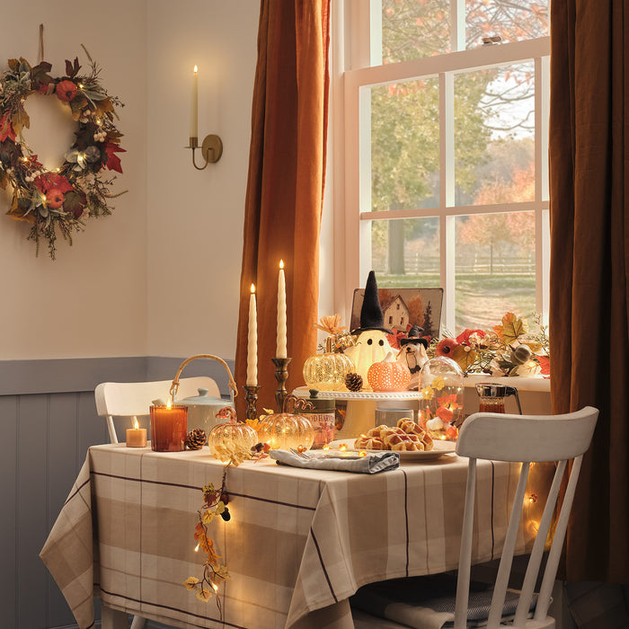 Table decorated with LED candles, pumpkin decorations and ghosts