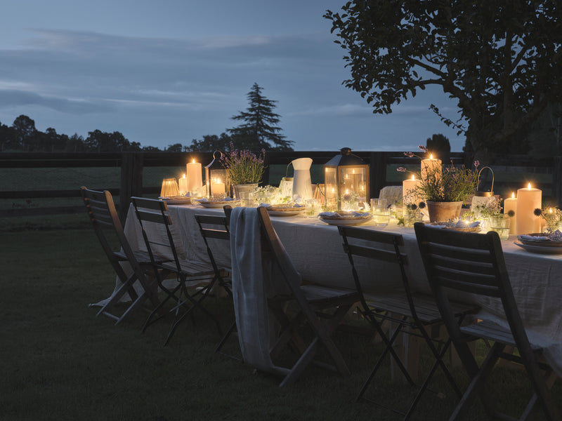 Outdoor dining table set with LED candles and lanterns