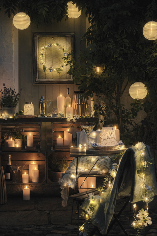Outdoor bistro nook lit with LED candles and lanterns