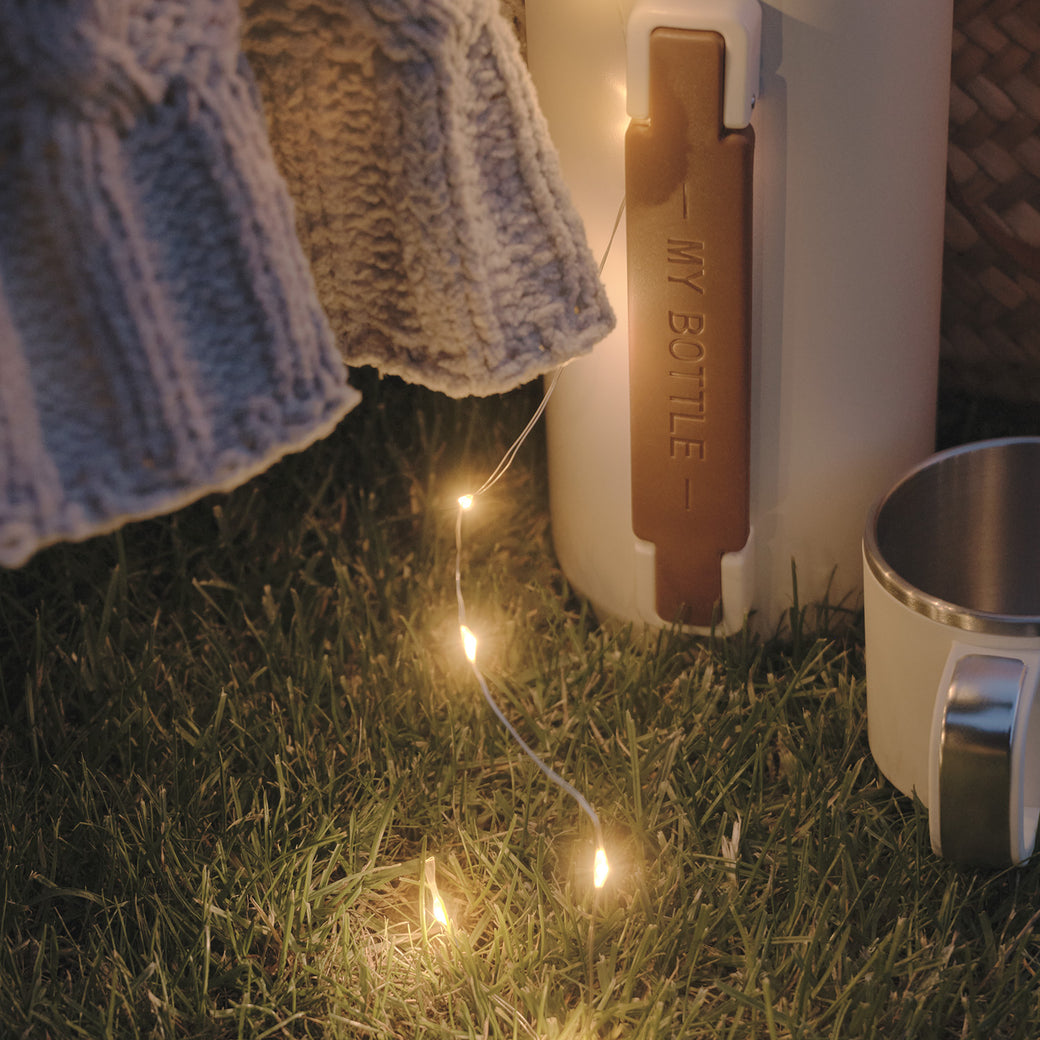 Micro lights next to a travel flask