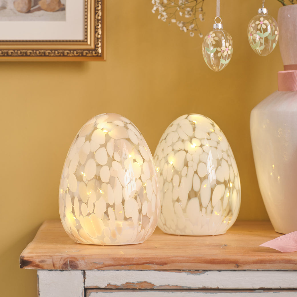 Set of 2 confetti glass egg decorations on a table