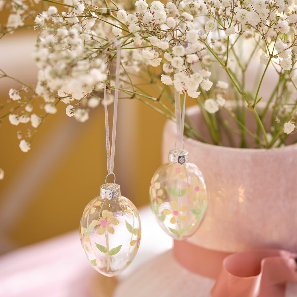 Glass egg decorations hanging from a plant