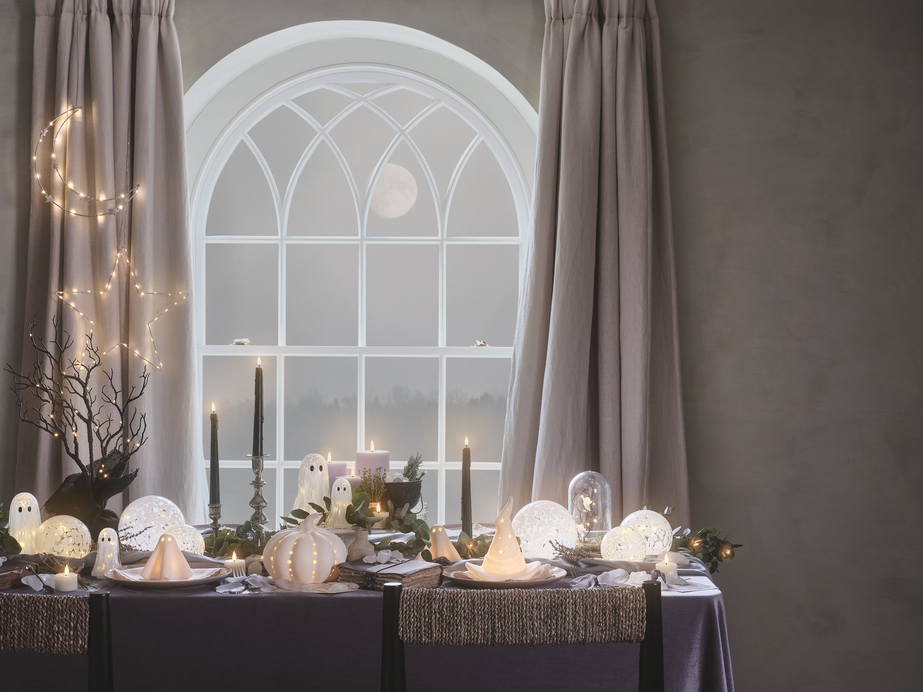 A table decorated with LED candles and ghost decorations