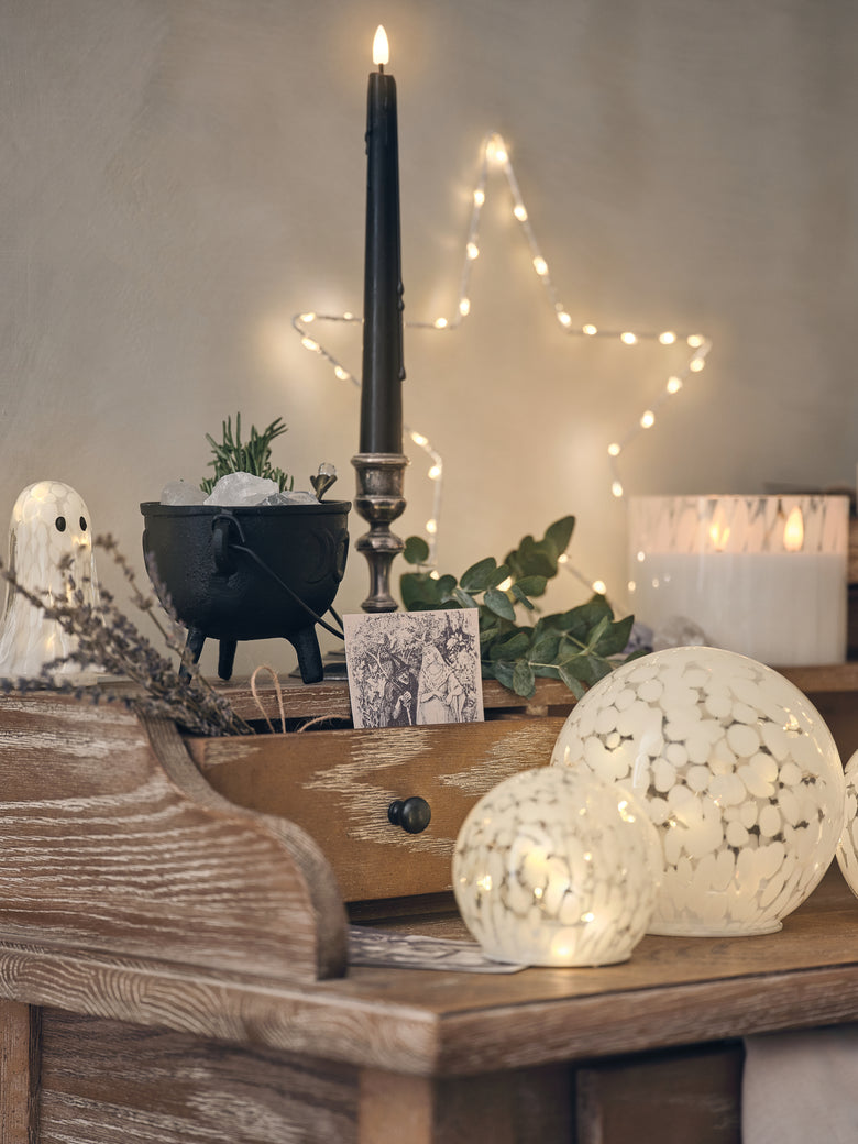 Side table decorated with LED candles and Halloween decorations