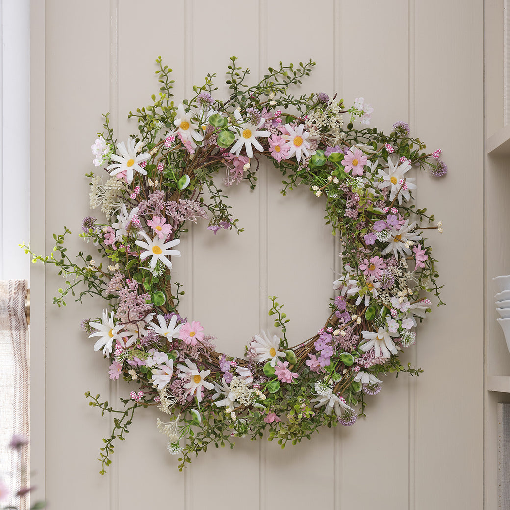 Pastel daisy wreath hung on a wall
