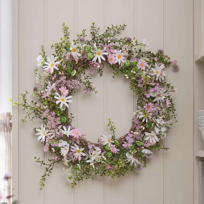 Pastel daisy wreath hung on a wall