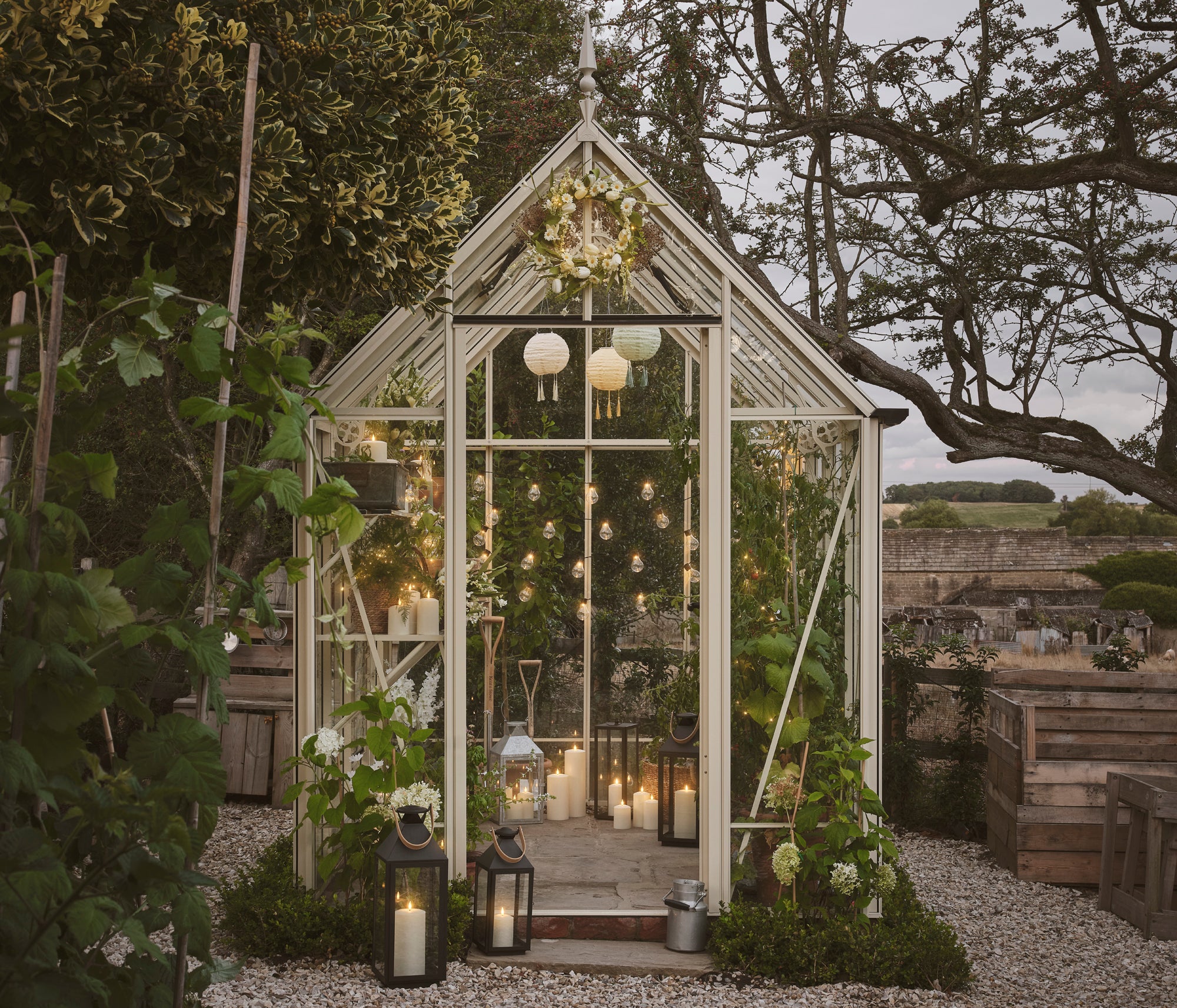 A greenhouse filled with LED candles, festoon lights, and lanterns