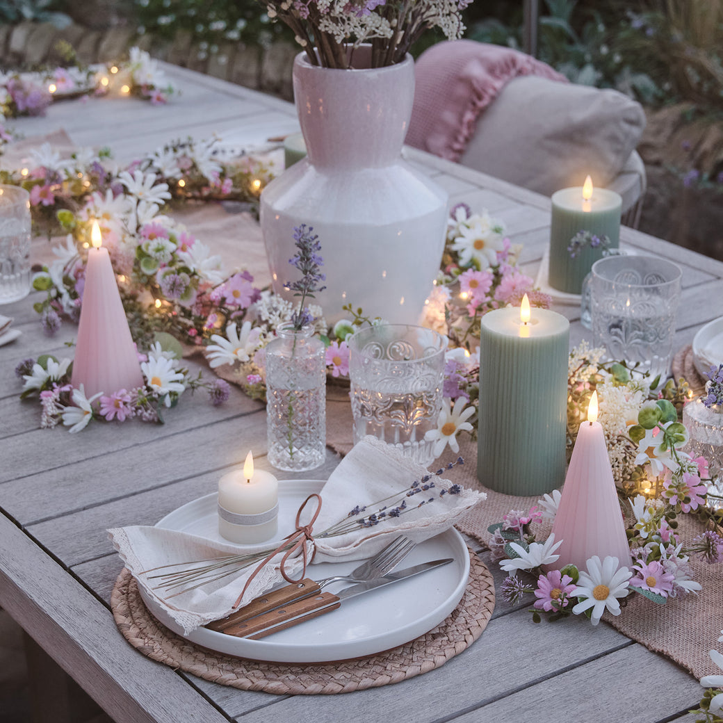 Garden table with candles, flowers, and place settings