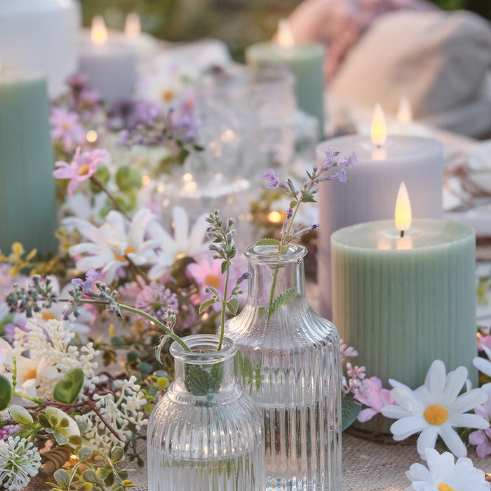 LED candles on a table with flower garlands and flowers in vases