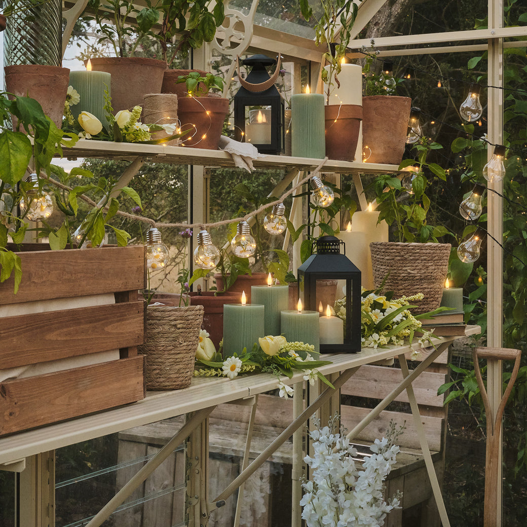 Greenhouse with LED green candles, daisy festoon lights and butter yellow tulip flowers on shelves