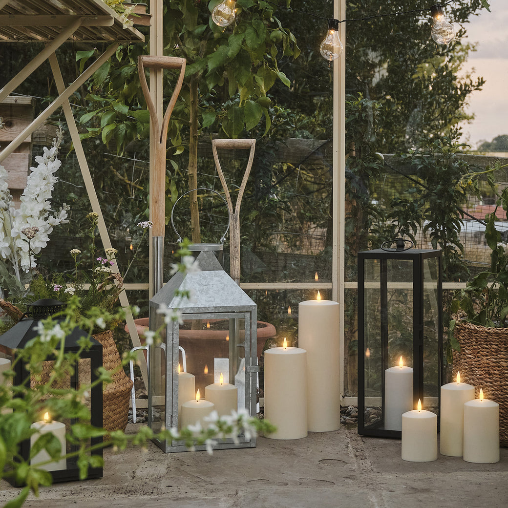 LED candles and lanterns on the floor of a greenhouse