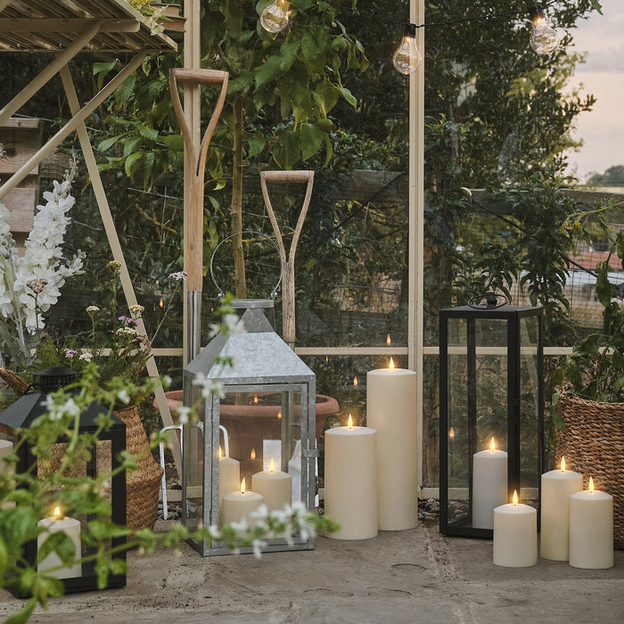 LED candles and lanterns on the floor of a greenhouse