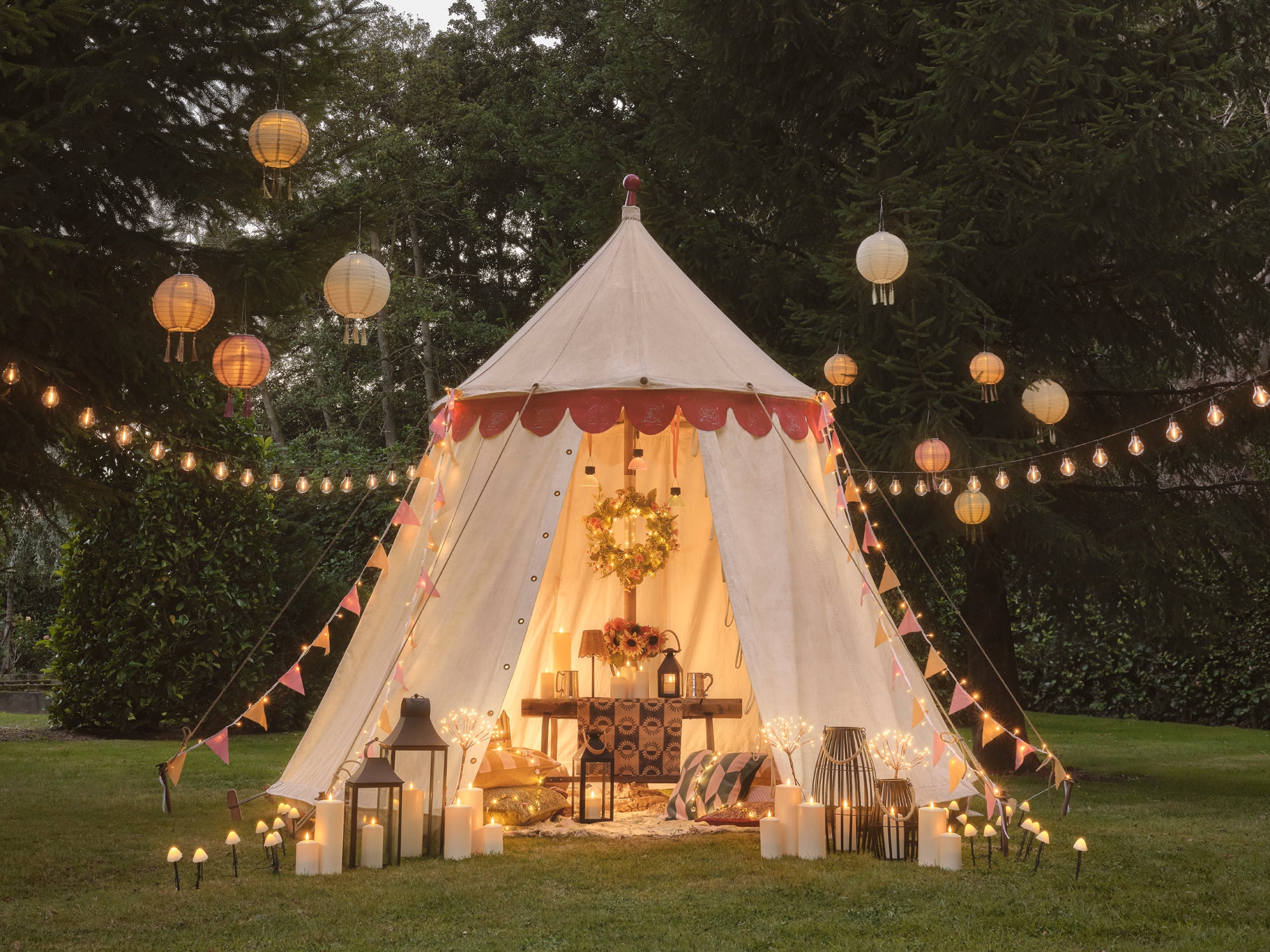 A festival tent with LED candles, lanterns, fairy lights and festoon lights.