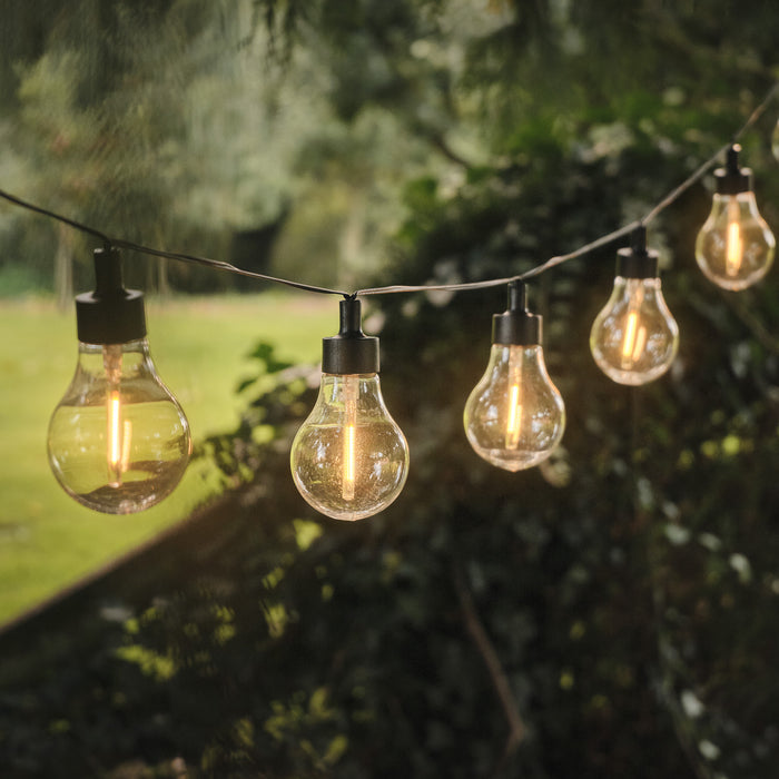 Warm white vintage festoon lights hanging between tree branches