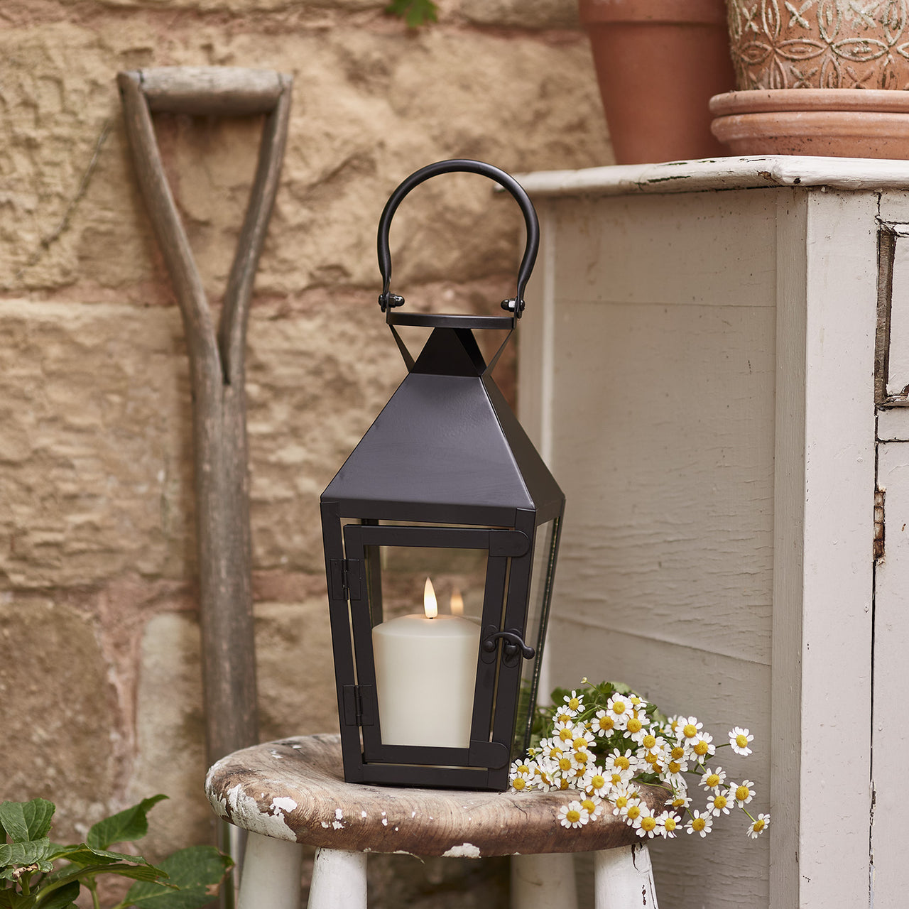 https://www.lights4fun.co.uk/cdn/shop/products/LA20022_cairns-black-garden-lantern-with-truglow-candle.jpg?v=1683810541&width=1280